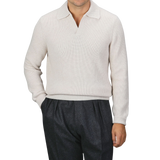 A person is wearing an Ecru Beige Chunky Knit Wool Polo Shirt by Gran Sasso, paired with dark gray pants. The background is plain gray.