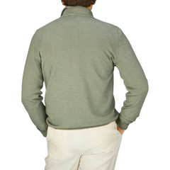 The back view of a man wearing a Gran Sasso Grass Green Vintage Merino Wool 1/4 Zip Sweater and white pants.