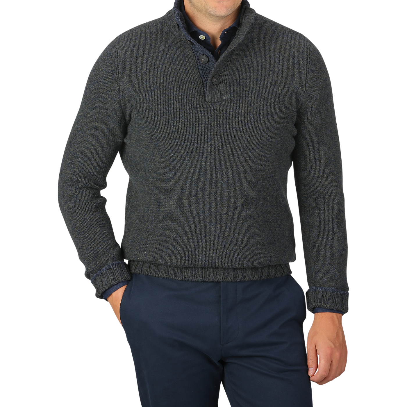 A person wearing a Gran Sasso Green Melange Wool Quarter Button Sweater paired with dark blue trousers is standing with one hand in a trouser pocket against a grey background.