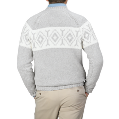 A person wearing a Gran Sasso Grey Eco Cashmere Norwegian Crewneck Sweater, featuring a white geometric pattern on the back, pairs it with beige pants and stands against a plain background.