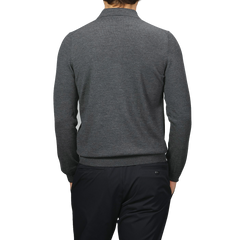 A man in a Gran Sasso grey Extra Fine Merino Wool Polo Shirt and black pants stands with his back to the camera against a neutral backdrop.