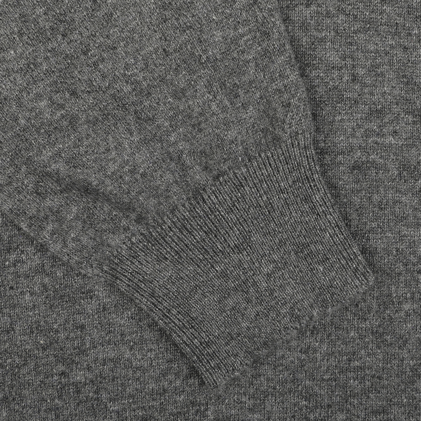 Close-up of a Gran Sasso Grey Melange Cashmere 1/4 Zip Sweater, focusing on a ribbed cuff. The texture of the material is visible, showing fine stitching and a consistent knitting pattern. This premium knitwear exhibits exceptional craftsmanship that's evident in every detail.