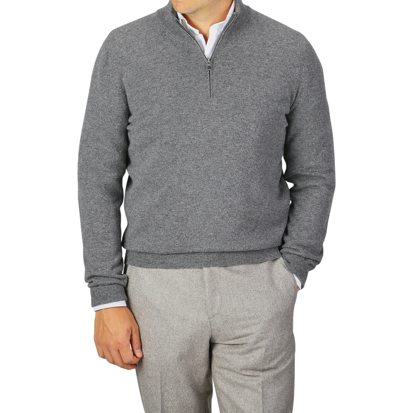 A person wearing a Gran Sasso Grey Melange Wool Cashmere 1/4 Zip Sweater over a white shirt and light grey pants stands with one hand in their pocket. The solid gray background complements the sustainable knitwear, creating a cohesive look.