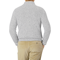 A person stands facing backwards, wearing a Gran Sasso Grey Melange Wool Quarter Button Sweater and beige corduroy pants.