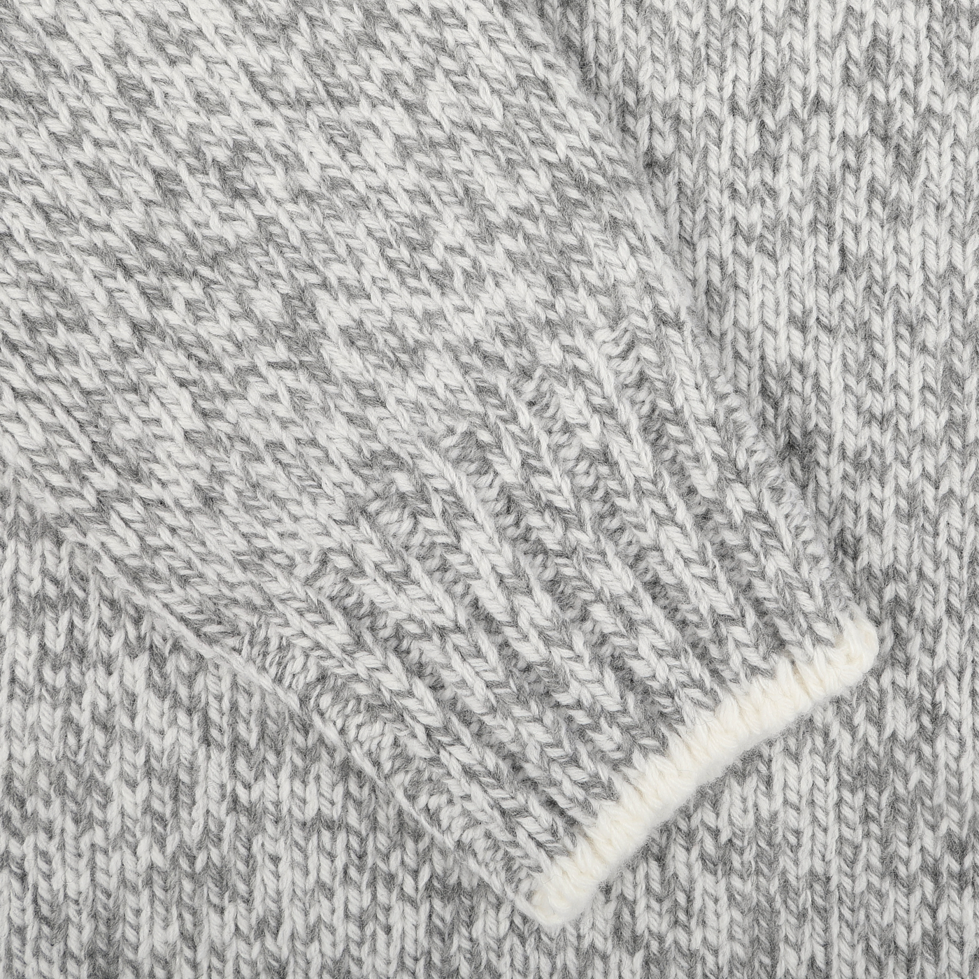 Close-up of the Grey Melange Wool Quarter Button Sweater by Gran Sasso, highlighting the texture and pattern of the pure merino wool material. The fabric appears to be part of a sleeve with ribbed cuffs, showcasing its contemporary fit.