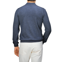 Person in a Gran Sasso Indigo Blue Extra Fine Merino Wool Polo Shirt and white pants, viewed from the back against a neutral background.