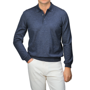 A person wearing a Gran Sasso Indigo Blue Extra Fine Merino Wool Polo Shirt and white pants stands against a gray background.