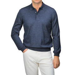 A person wearing a Gran Sasso Indigo Blue Extra Fine Merino Wool Polo Shirt and white pants stands against a gray background.