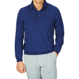 A person wearing an Indigo Blue Organic Cotton LS Gran Sasso polo shirt paired with light gray trousers.