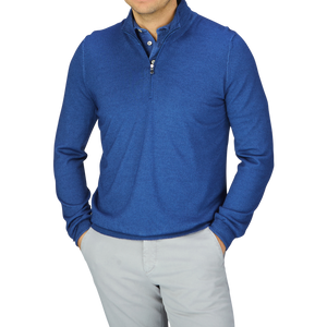 A man wearing a Indigo Blue Vintage Merino Wool 1/4 Zip Sweater by Gran Sasso and gray pants.
