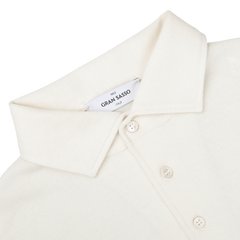 A close-up of an Ivory Merino Wool One-Piece Collar Polo Shirt with long sleeves, featuring three buttons and a 'Gran Sasso' label on the inside of the collar.