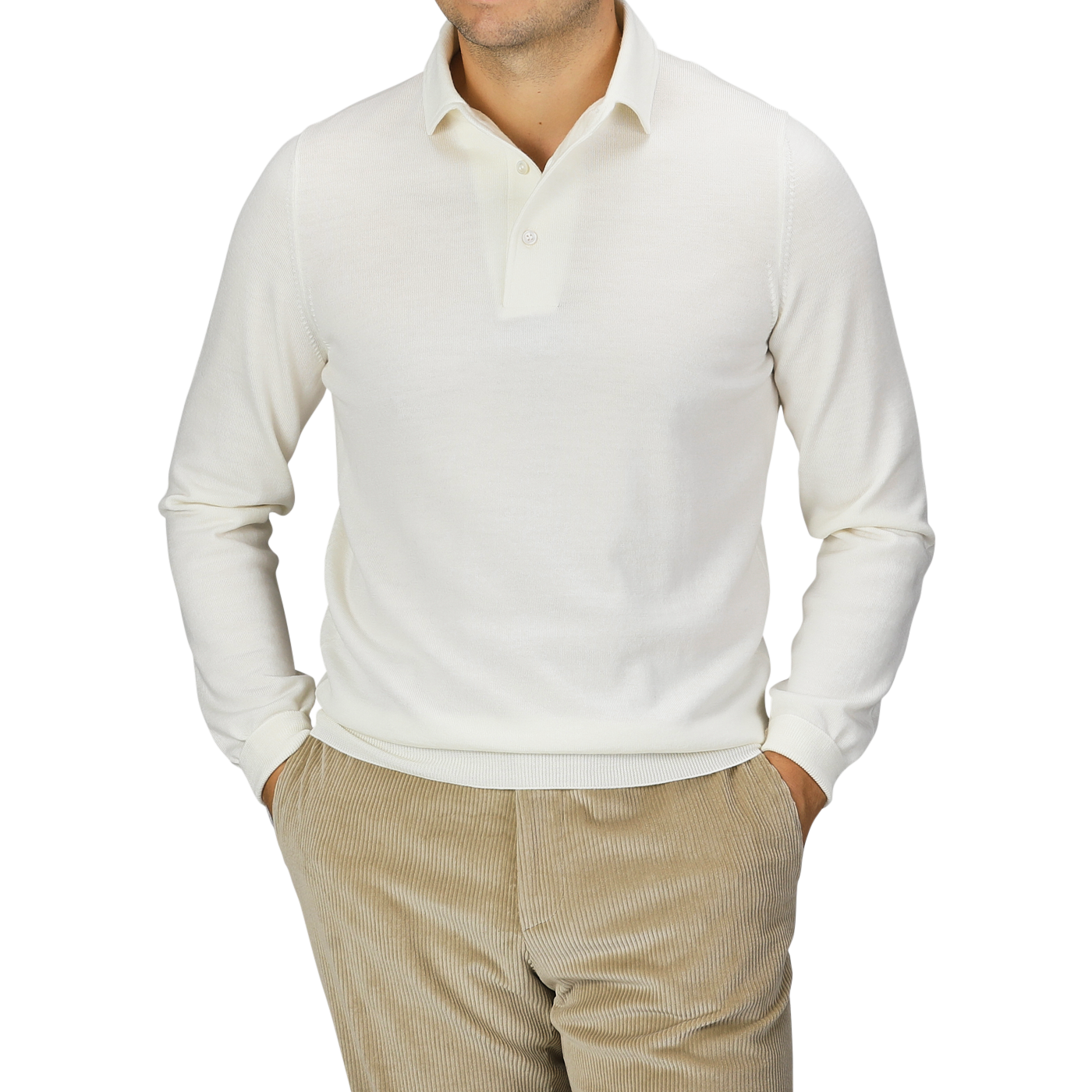 A man wearing a Gran Sasso Ivory Merino Wool One-Piece Collar Polo Shirt with beige corduroy pants, hands in his pockets, stands against a plain background.