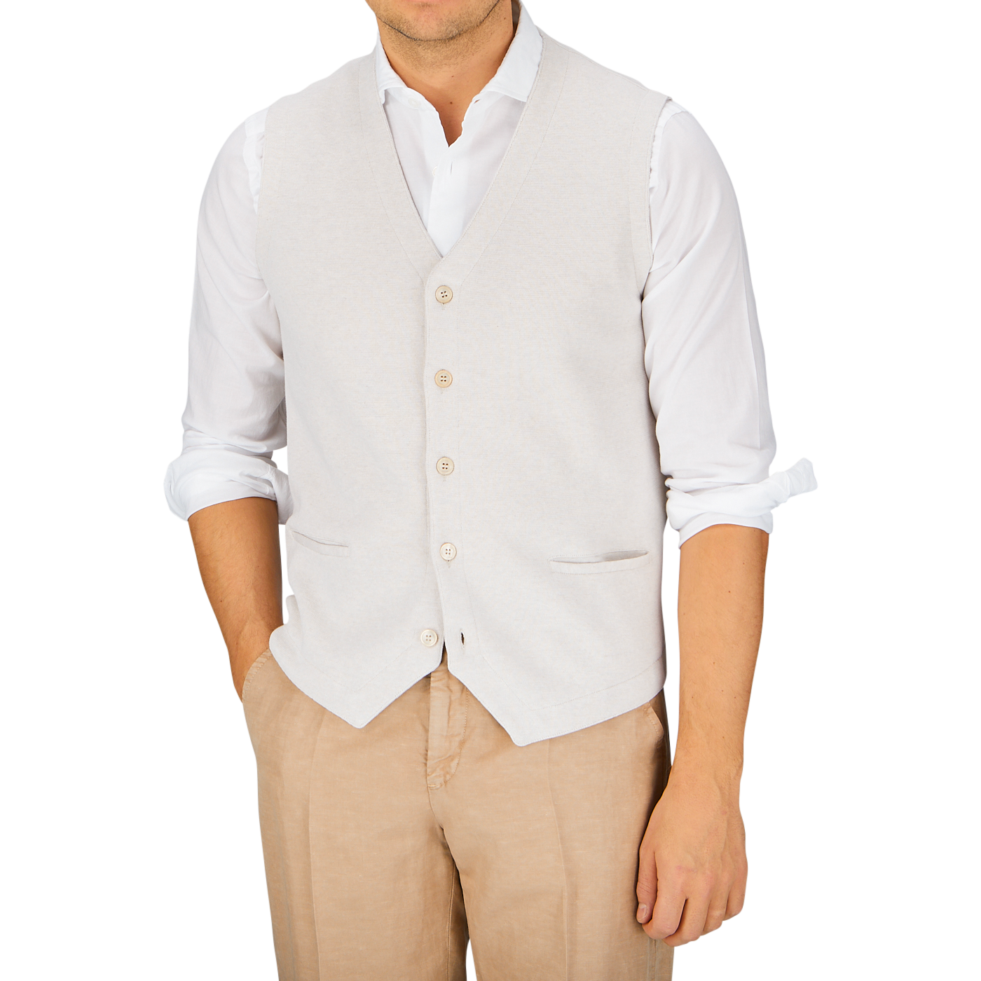 Man wearing a white cotton dress shirt and a Gran Sasso gray knitted vest with hands in the pockets of his Gran Sasso light beige fresh cotton knitted waistcoat trousers.
