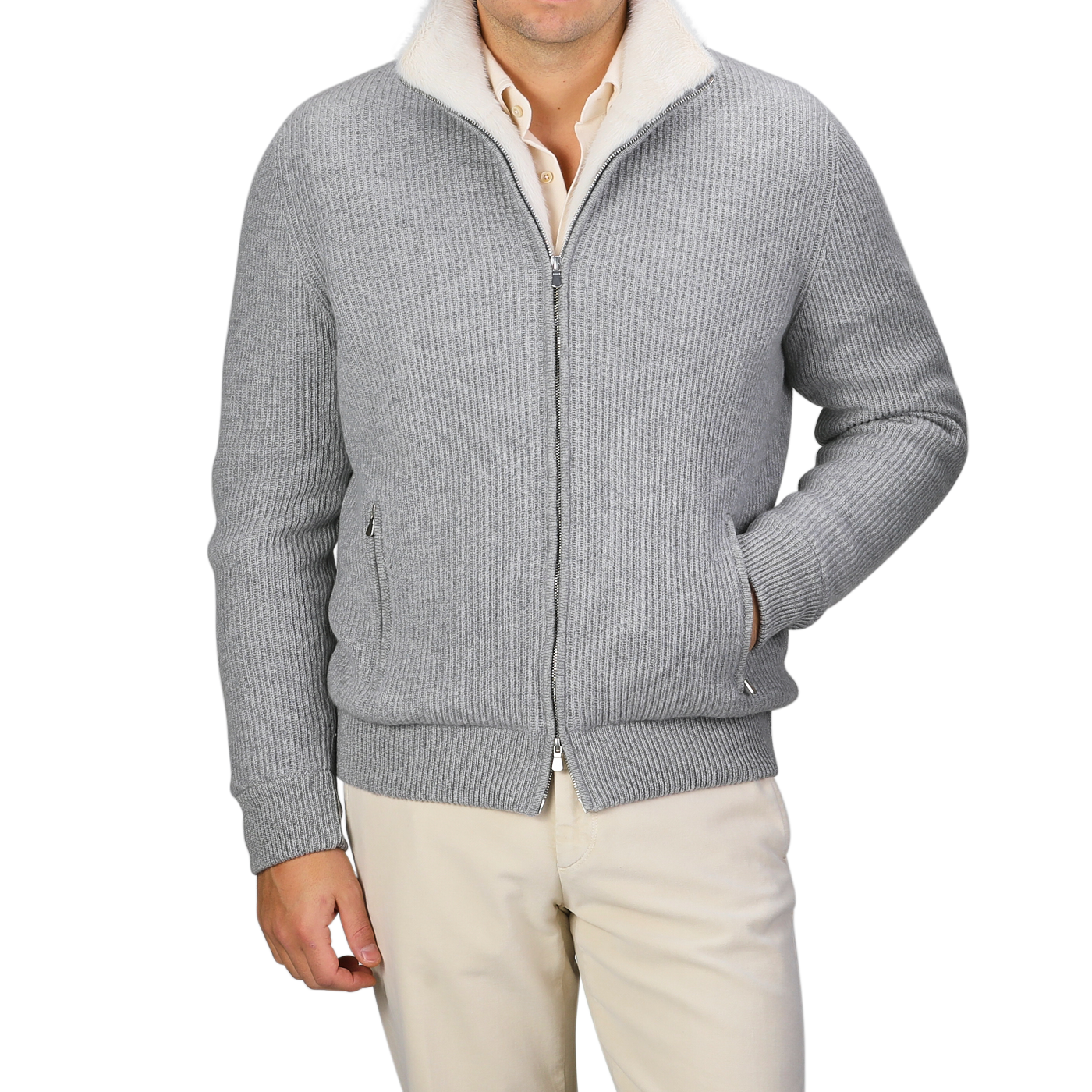 A person wearing a Gran Sasso Light Grey Faux Fur Lined Cashmere Blouson paired with off-white pants stands against a neutral background, with their right hand casually placed in their pocket, embodying the essence of luxury knitwear.