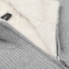 Close-up of the Light Grey Faux Fur Lined Cashmere Blouson by Gran Sasso, showcasing luxury knitwear style with a silver zipper and a hint of soft cream-colored fleece lining.