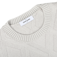 Close-up of the Gran Sasso Light Grey Wool Cashmere Diamond Knit Sweater, highlighting its durable and comfortable textured diamond knit pattern and featuring a white label at the neckline.