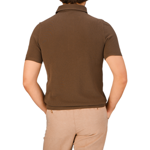 A person seen from the back wearing a Gran Sasso Mid-Brown Fresh Cotton Mesh Polo Shirt and beige trousers.