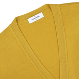 Close-up of a mustard yellow Gran Sasso Extra Fine Merino cardigan with a V-neck, perfect for layering. The brand label is visible near the collar, and it's crafted from luxurious merino wool.