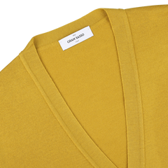 Close-up of a mustard yellow Gran Sasso Extra Fine Merino cardigan with a V-neck, perfect for layering. The brand label is visible near the collar, and it's crafted from luxurious merino wool.