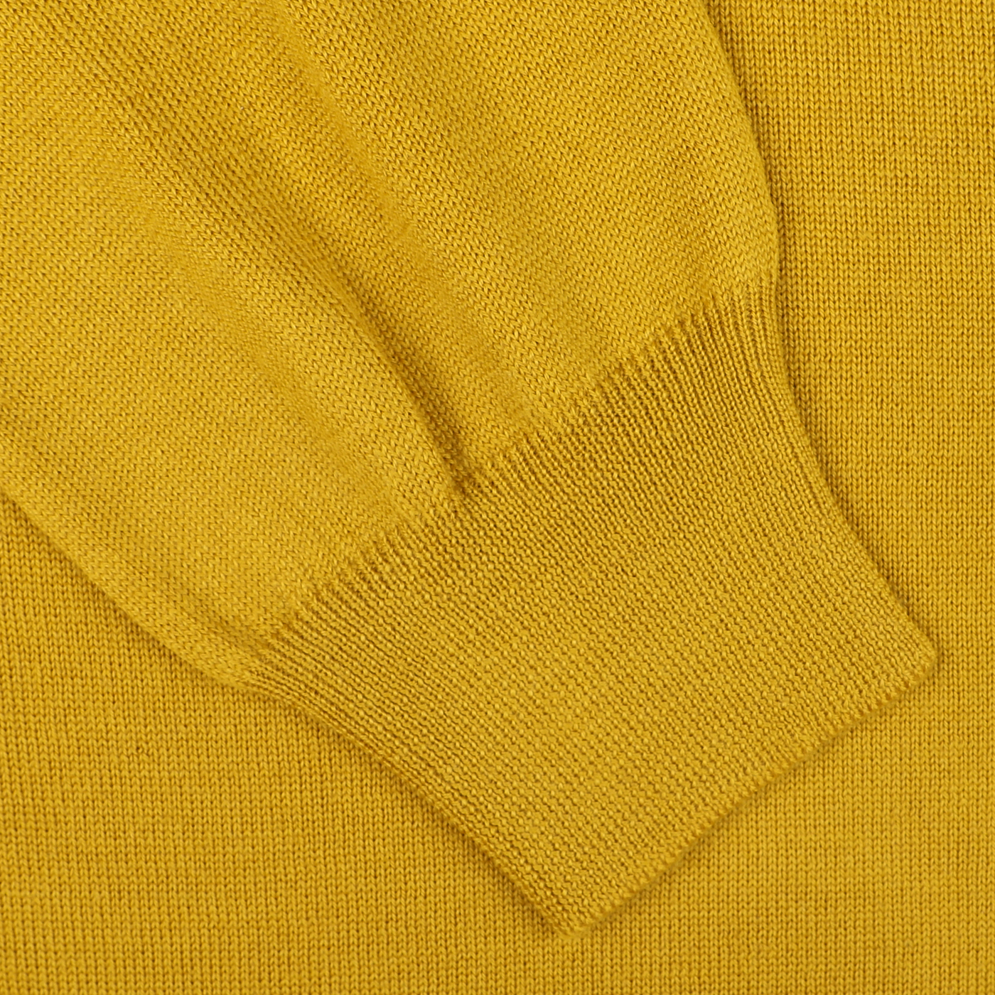 Close-up of a Gran Sasso Mustard Yellow Extra Fine Merino Cardigan sleeve, showcasing the ribbed cuff and rich fabric texture, ideal for layering.