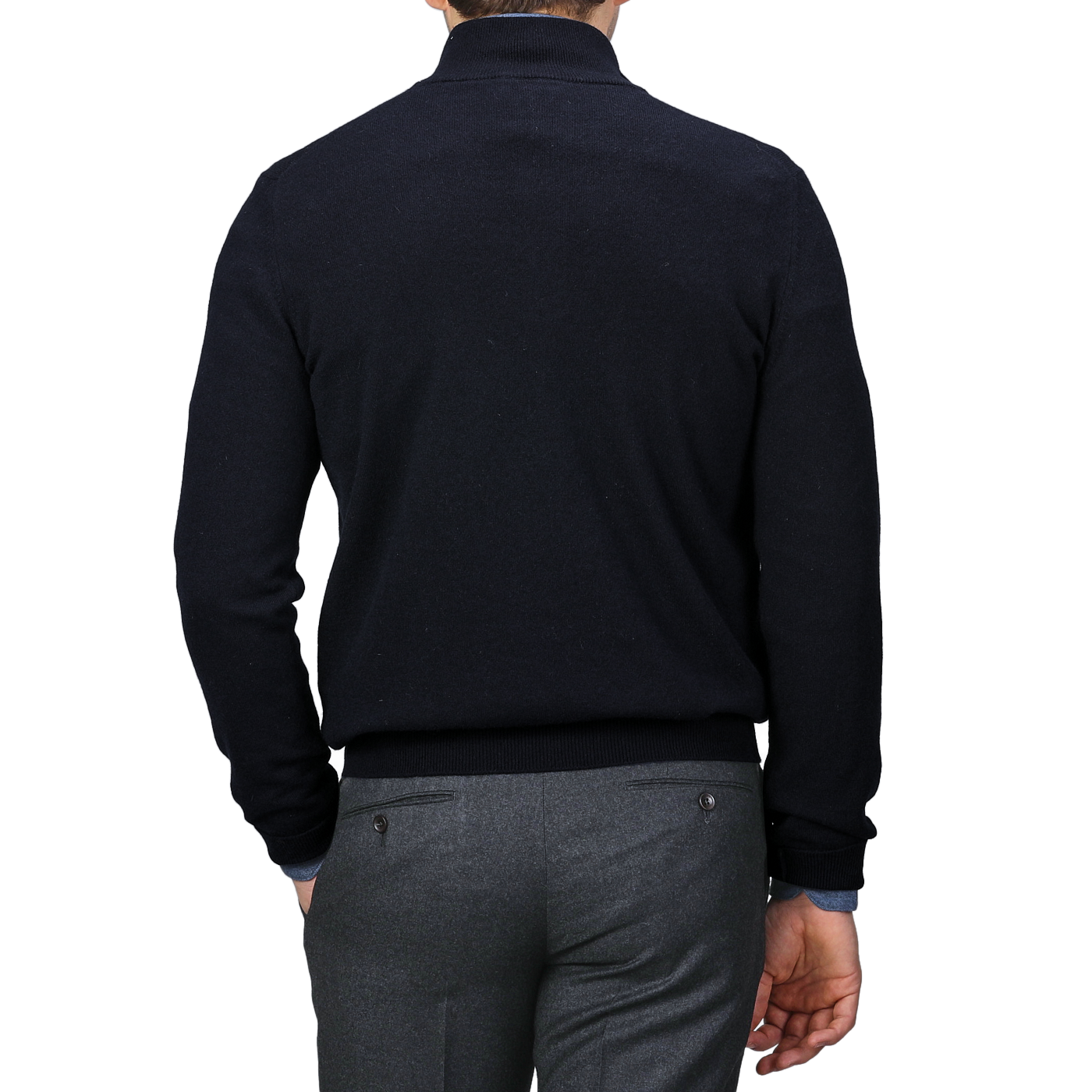 A person is shown from the back, wearing a luxurious Gran Sasso navy blue cashmere 1/4 zip sweater paired with gray pants against a monochromatic gray background.