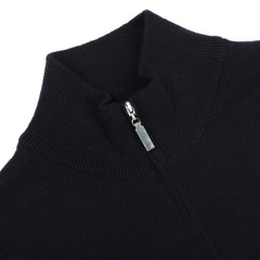 Close-up of a premium knitwear piece, this navy blue cashmere 1/4 zip sweater by Gran Sasso features a high collar and a partially unzipped silver zipper.