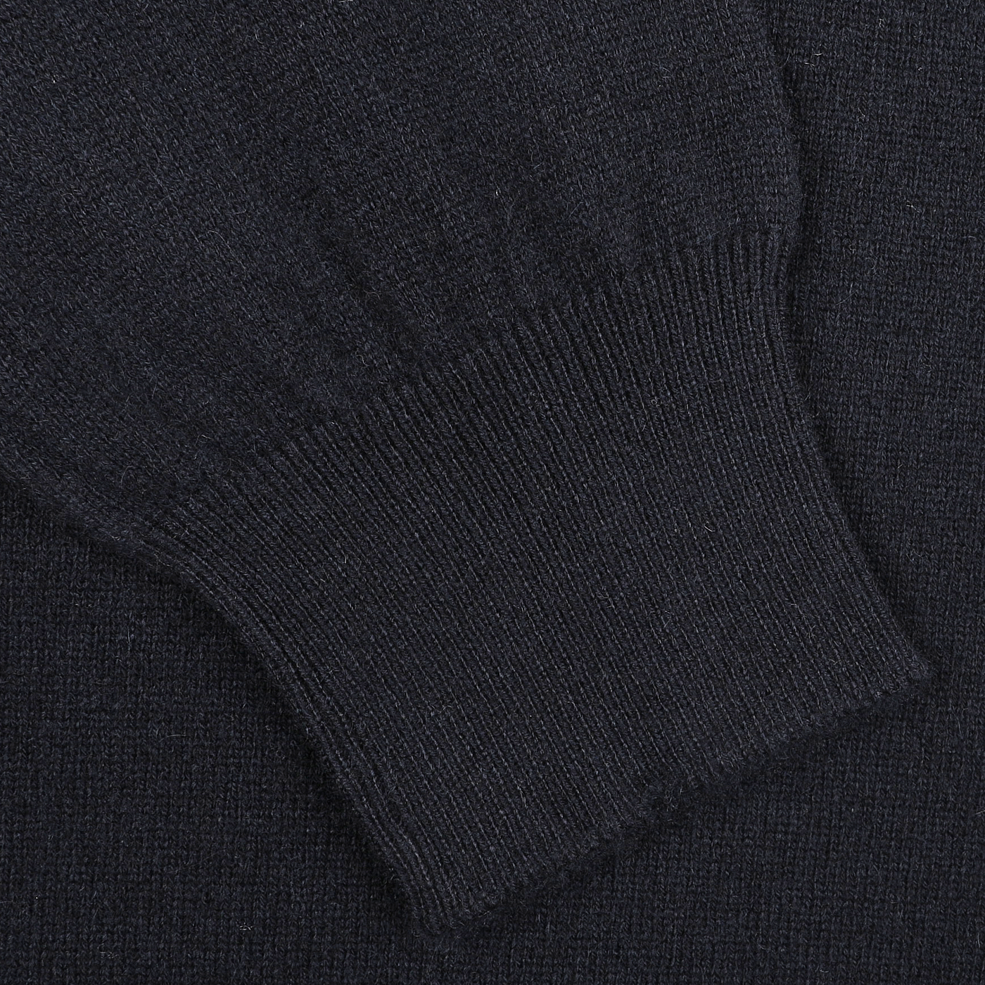 Close-up of a navy blue Gran Sasso cashmere crewneck sweater sleeve with a ribbed cuff, highlighting exquisite knitwear.