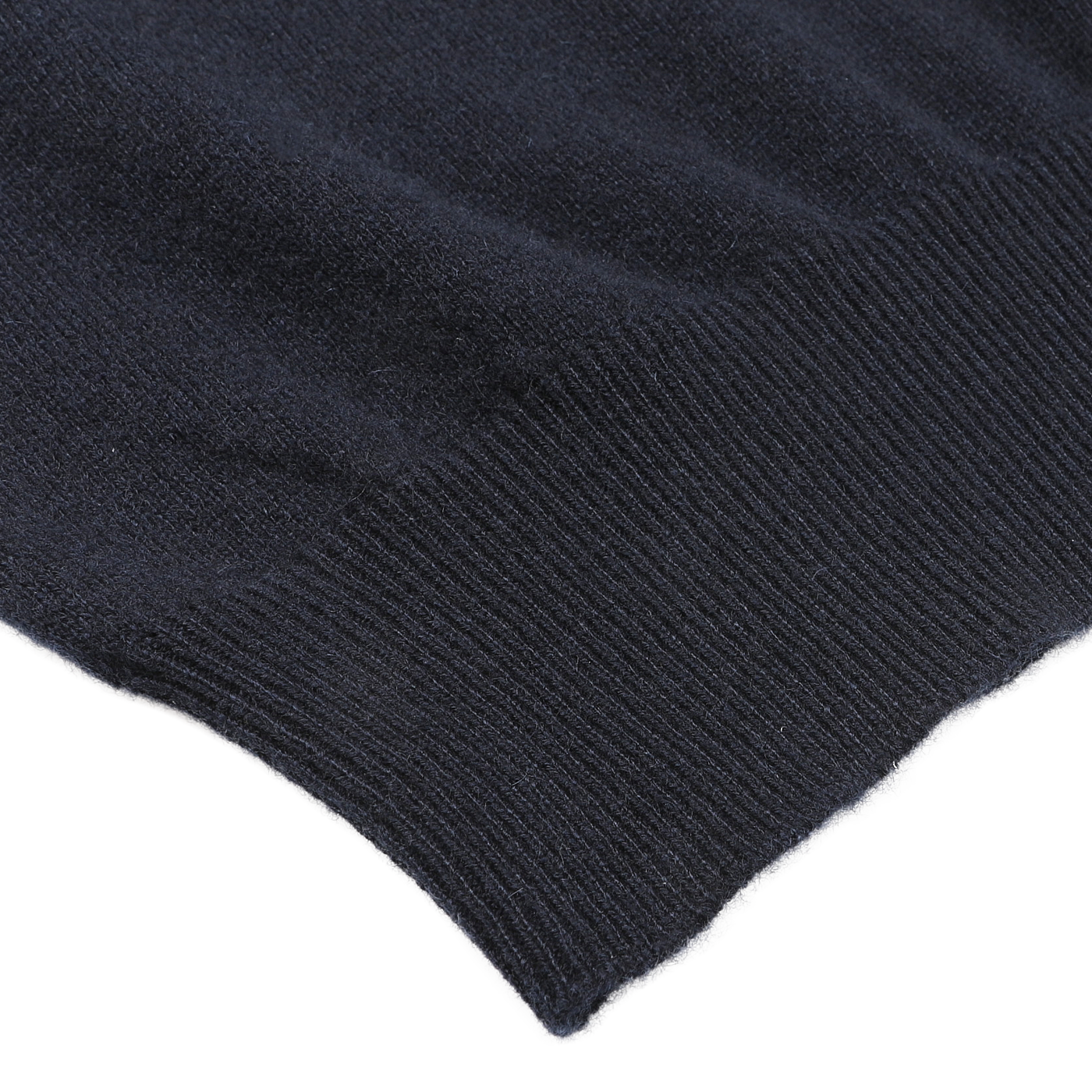 Close-up of the edge of a dark-colored knitted fabric with ribbing detail, showcasing texture and pattern. This Navy Blue Cashmere Crewneck Sweater by Gran Sasso exemplifies sustainable knitwear, highlighting its fine craftsmanship.