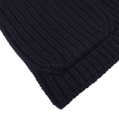 Close-up of a folded, navy blue, chunky cable-knit fabric with a ribbed pattern, crafted from pure wool thread by Gran Sasso for their Wool Cardigan collection.