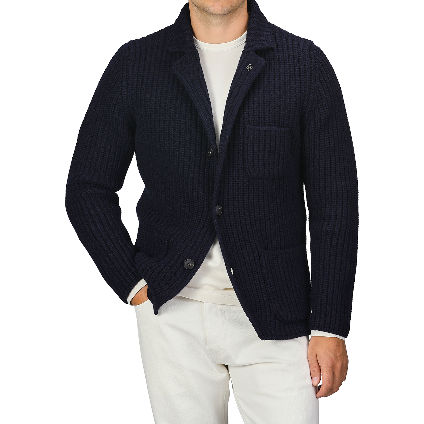 A person wearing a Gran Sasso Navy Blue Chunky Knitted Wool Cardigan over a white shirt and white pants. Their left hand is in their pocket.