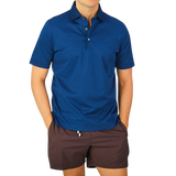 A man wearing a Navy Blue Cotton Filo Scozia Polo Shirt by Gran Sasso.