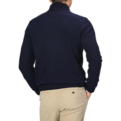 A person wearing a Gran Sasso Navy Blue Felted Cashmere Zip Cardigan and beige pants is shown from the back, with one hand in their pocket and a short haircut visible above the sweater collar.