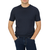 The man is wearing navy blue Gran Sasso jeans and a lightweight Gran Sasso blue knitted silk t-shirt.