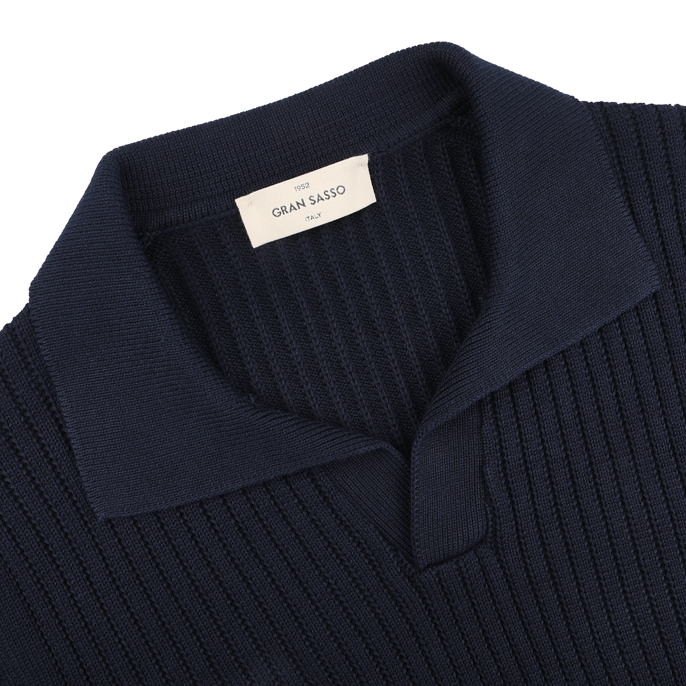 Close-up of a chunky-knit navy blue polo shirt with a collar, labeled "Gran Sasso," made from organic cotton.