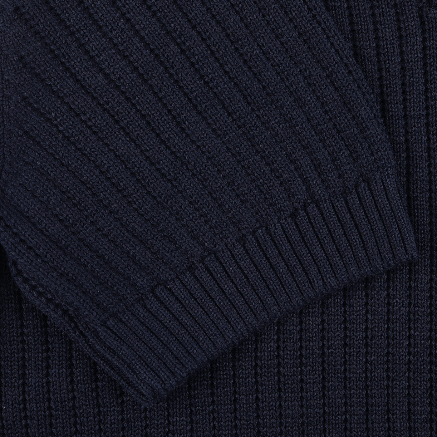 Close-up of a navy blue chunky-knit fabric displaying the sleeve and body of a stylish polo shirt from Gran Sasso, crafted from organic cotton.