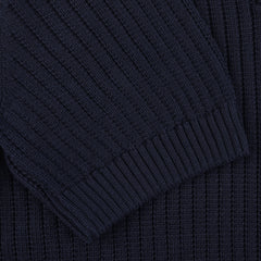 Close-up of a navy blue chunky-knit fabric displaying the sleeve and body of a stylish polo shirt from Gran Sasso, crafted from organic cotton.