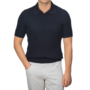 Person wearing a navy blue chunky-knit Gran Sasso polo shirt made of organic cotton and light gray pants against a plain background.