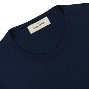Close-up of a navy blue organic cotton t-shirt with a "Gran Sasso" brand label.