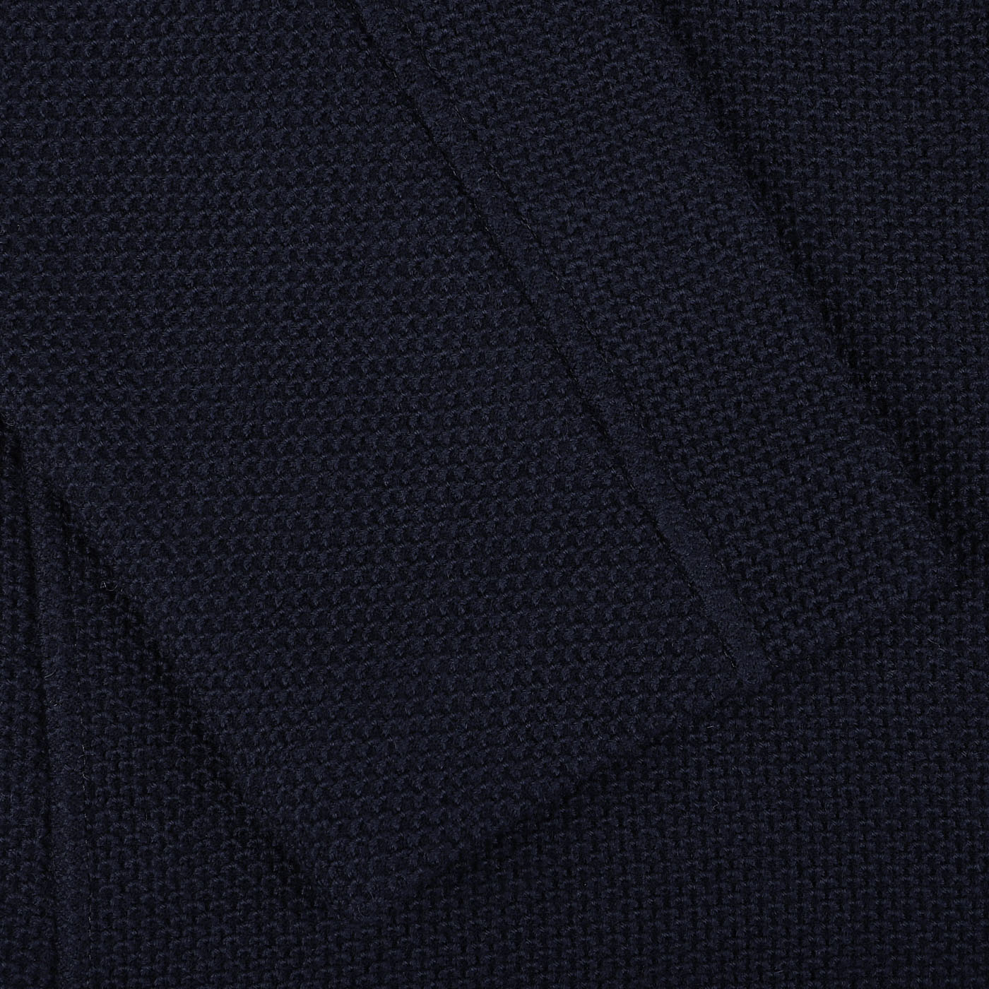 Close-up of a textured dark fabric with a rectangular fold or flap overlapping the main surface, reminiscent of the Gran Sasso Navy Blue Virgin Wool Sartorial Jacket.