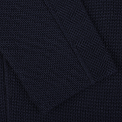 Close-up of a textured dark fabric with a rectangular fold or flap overlapping the main surface, reminiscent of the Gran Sasso Navy Blue Virgin Wool Sartorial Jacket.