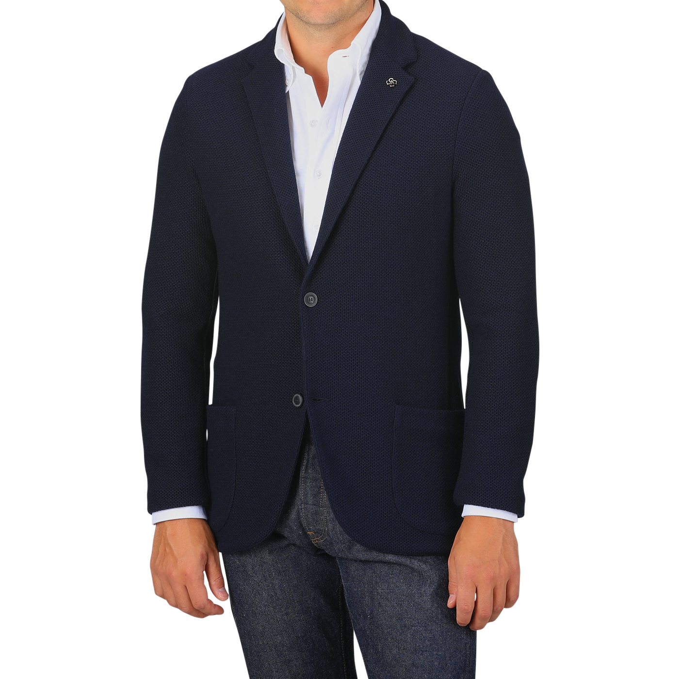 A man wearing a Navy Blue Virgin Wool Sartorial Jacket by Gran Sasso over a white collared shirt and blue jeans. His hands are at his sides against a plain gray background.