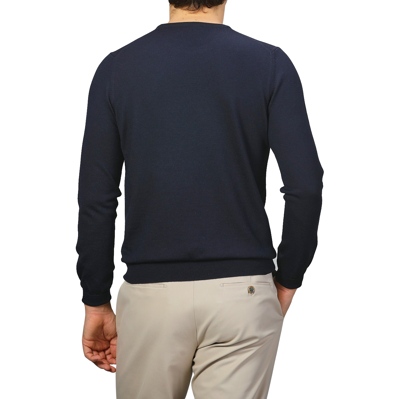 Wearing a Navy Extra Fine Merino Crew Neck by Gran Sasso and beige pants, a person stands against a gray background, adding cozy elegance to their wardrobe.