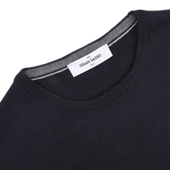 Close-up of a navy Gran Sasso sweater with the label inside the neck, highlighting its fine merino quality for added warmth.