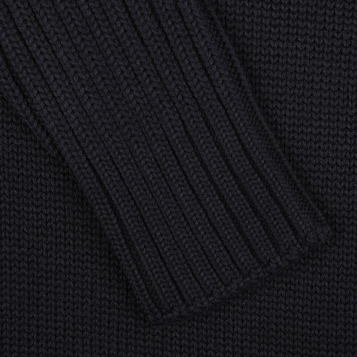 Close-up of a navy blue knitted fabric, showcasing a textured, ribbed pattern akin to the refined craftsmanship of Gran Sasso's Navy Rain Wool Rib Roll Neck.