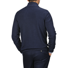 A person in a Navy Vintage Merino Wool Zip Cardigan by Gran Sasso and matching trousers made from pure virgin wool is shown from the back, hands in pockets.