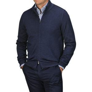 A person dressed in a Navy Vintage Merino Wool Zip Cardigan from Gran Sasso over a blue-and-white striped shirt with navy pants, viewed from the chest down.