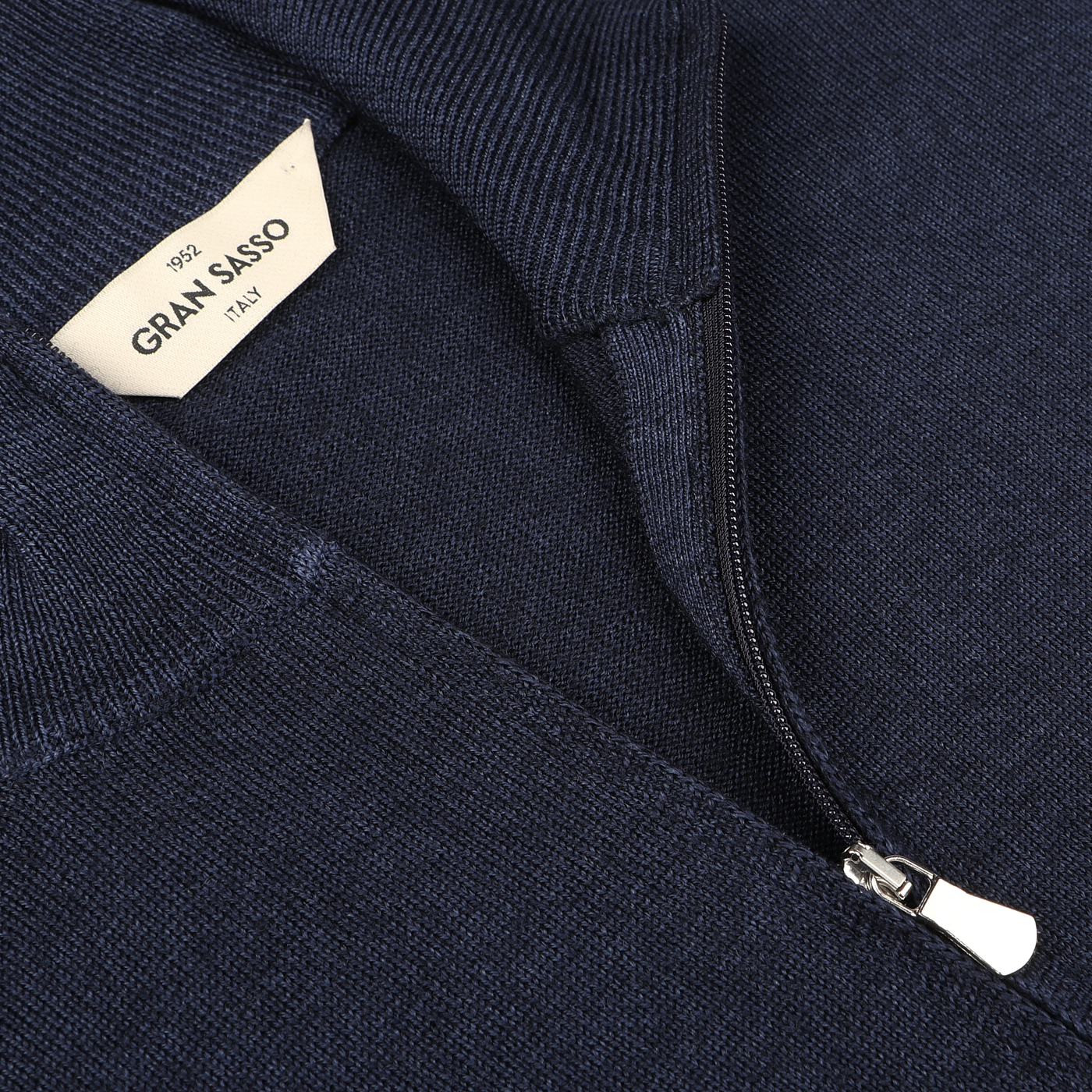 Close-up of the Navy Vintage Merino Wool Zip Cardigan from Gran Sasso, showcasing a visible label indicating the brand name and "Italy." Made from pure merino wool, this sweater exudes a vintage feel.