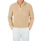 A man wearing a Gran Sasso oat beige rib stitch cotton 1/4 Zip sweater, paired with white pants.