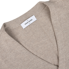 Close-up of an Oatmeal Beige Knitted Merino Wool Waistcoat by Gran Sasso, featuring a white label displaying "Gran Sasso Italy.