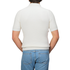 A person in an Off-White Organic Cotton Polo Shirt by Gran Sasso and blue jeans is facing away from the camera.